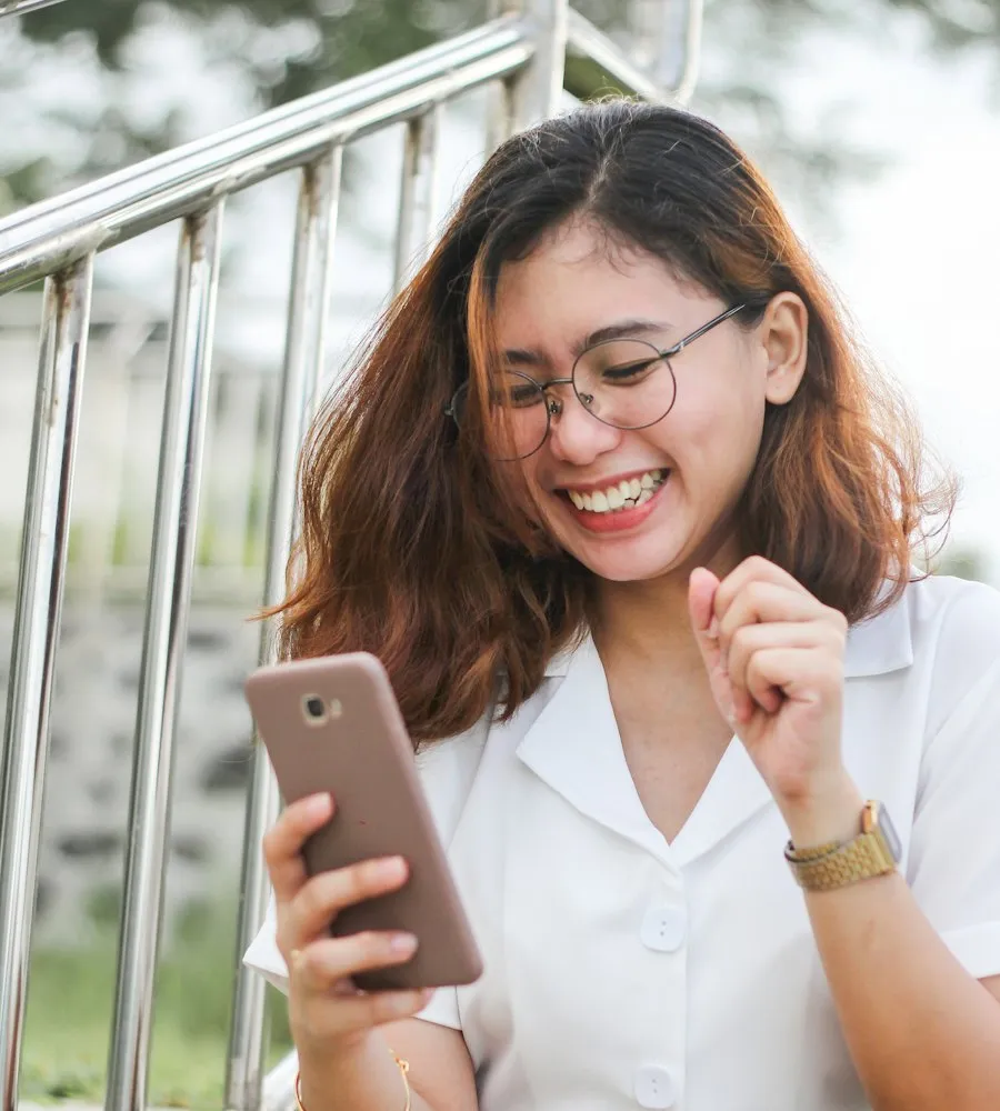 Mulher sorrindo com o celular na mão